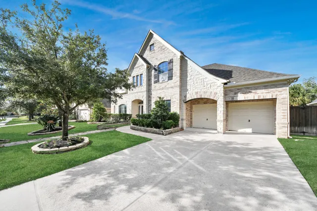 a front view of a house with a yard and trees
