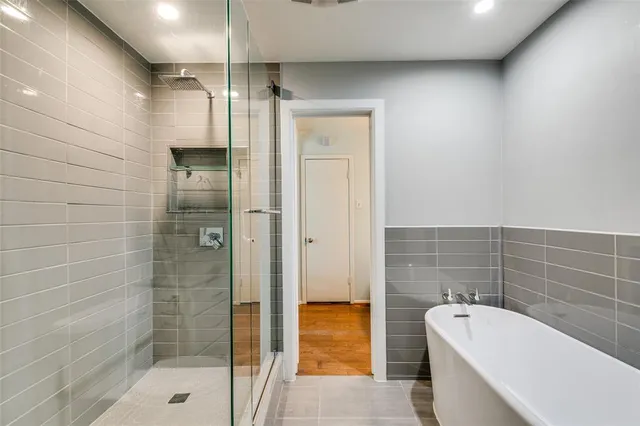 a bathroom with a tub a sink and shower