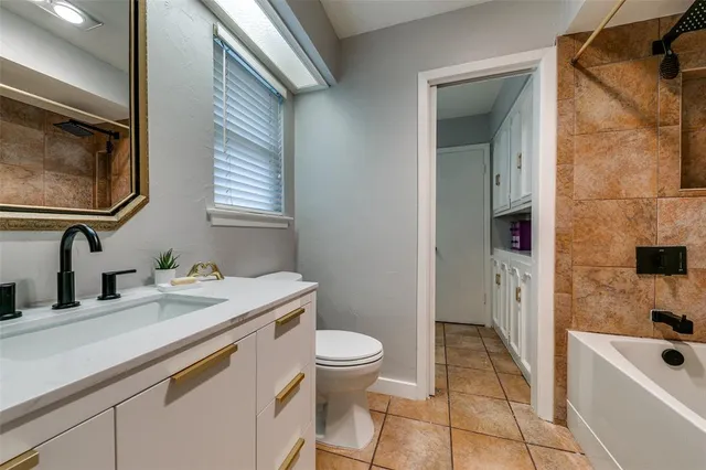 a bathroom with a sink a toilet a tub and mirror