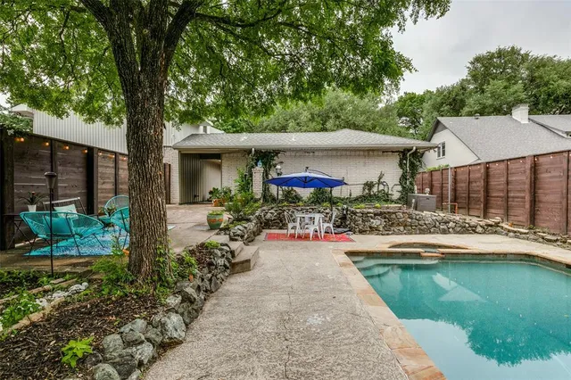a view of a house with backyard sitting area and swimming pool
