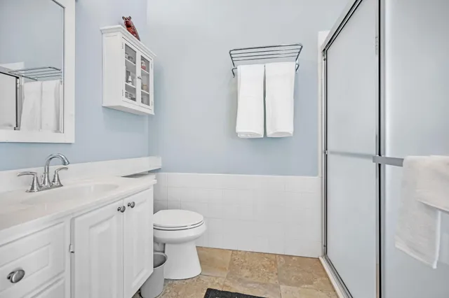 a bathroom with a granite countertop sink toilet and shower