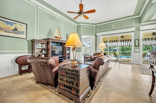 a living room with furniture a large window and a chandelier