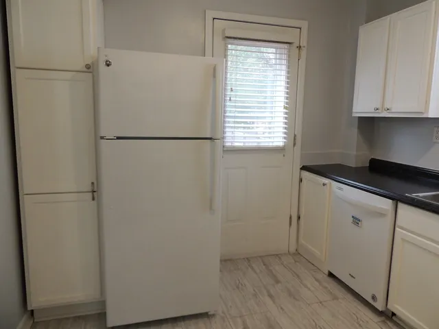 a view of a refrigerator in kitchen and a sink