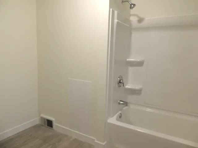 a white bath tub sitting next to a white sink and vanity
