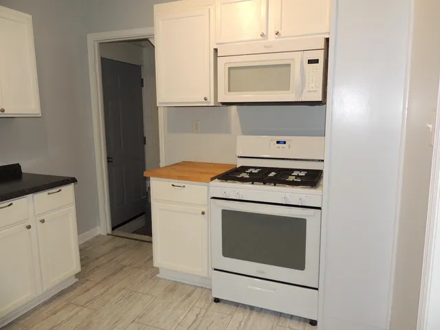 a stove top oven sitting inside of a kitchen