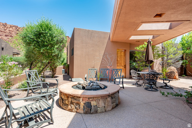 2331 West Entrada Trail, Unit 61 St. George, UT 84770 - Photo 5 of 69 Expansive outdoor patio featuring a stone fire pit, exposed aggregate concrete flooring, and a covered section with skylights
