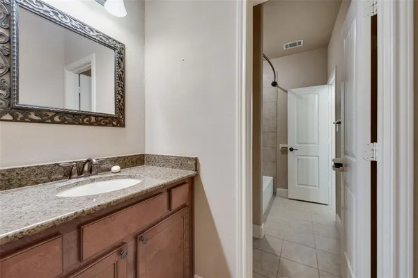 a bathroom with a granite countertop sink vanity and mirror