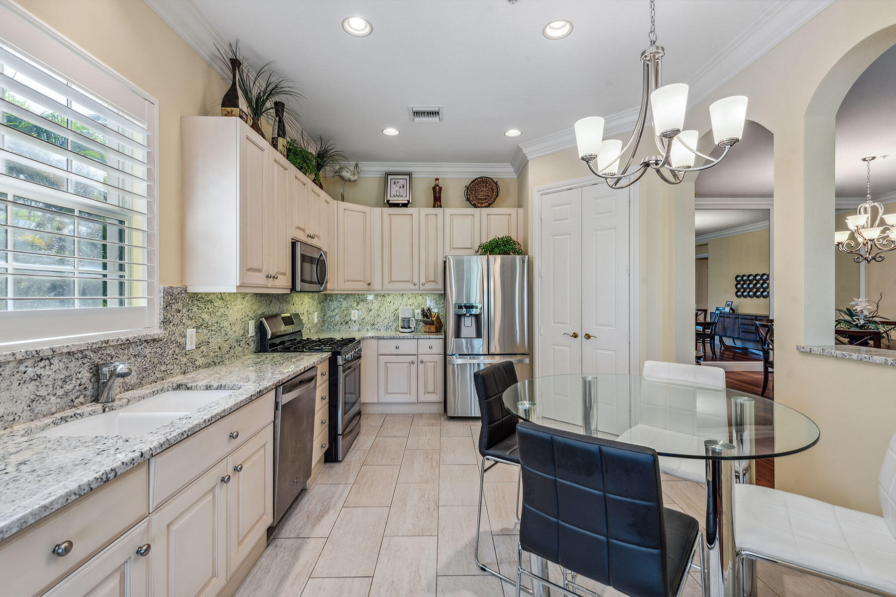 3189 Aviamar Circle, Unit 202 Naples, FL 34114 - Photo 8 of 50 a large kitchen with granite countertop a sink white cabinets and stainless steel appliances