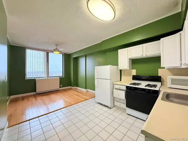 a bedroom with a bed and a dresser next to a window