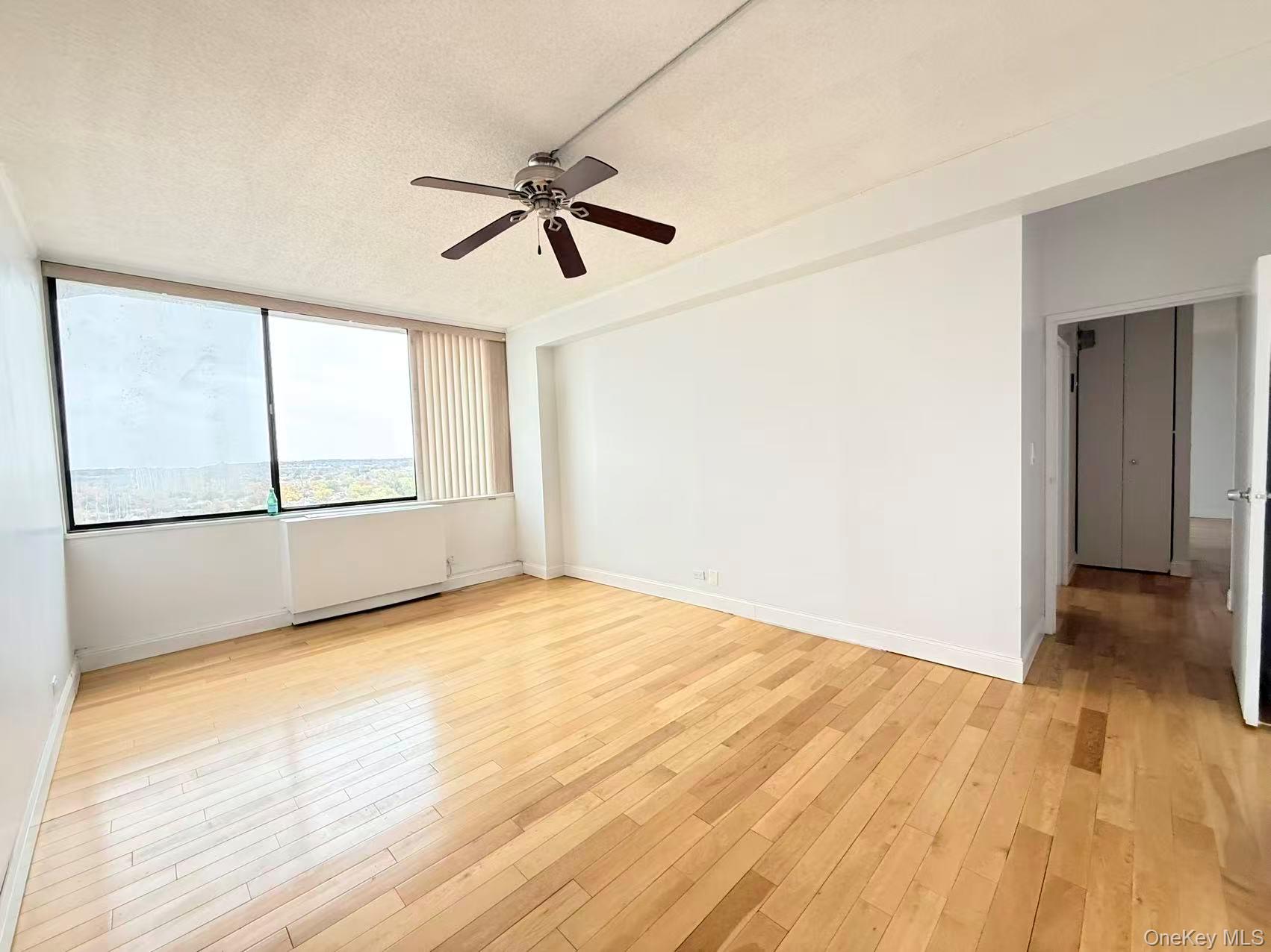 2 Bay Club Drive, Unit PHJ Queens, NY 11360 - Photo 9 of 17 a view of empty room with wooden floor and fan