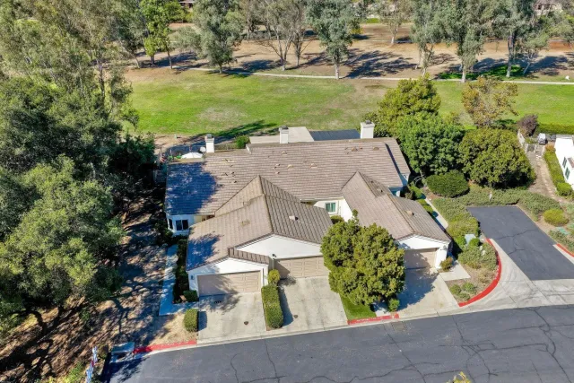 an aerial view of a house with a garden and lake view