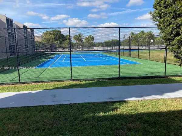 a front view of a house with a yard and palm trees