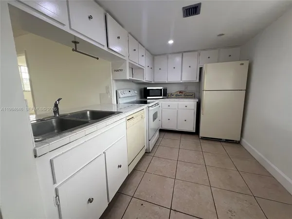 a kitchen with cabinets appliances a sink and a counter top space