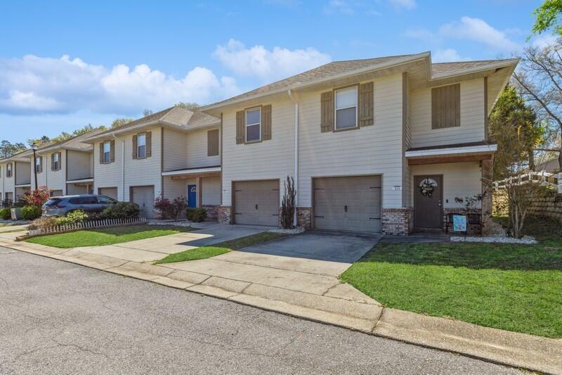 513 Arbor Lake Drive, Unit 513 Crestview, FL 32536 - Photo 2 of 37 a front view of a house with a yard and trees