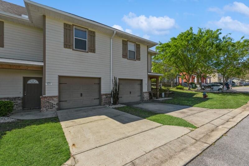 513 Arbor Lake Drive, Unit 513 Crestview, FL 32536 - Photo 3 of 37 a front view of a house with a yard and garage
