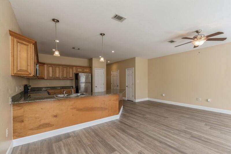 513 Arbor Lake Drive, Unit 513 Crestview, FL 32536 - Photo 8 of 37 a view of a kitchen with a sink dishwasher a refrigerator with wooden cabinets and floor