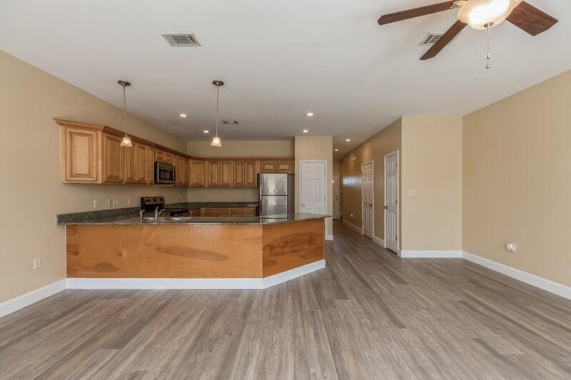 513 Arbor Lake Drive, Unit 513 Crestview, FL 32536 - Photo 9 of 37 a large kitchen with stainless steel appliances granite countertop a large counter top a sink and a chandelier