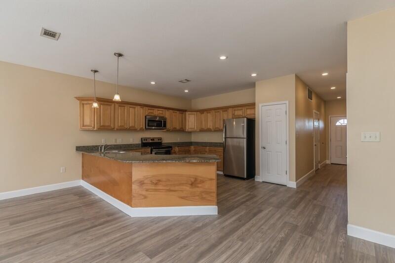 513 Arbor Lake Drive, Unit 513 Crestview, FL 32536 - Photo 10 of 37 a room with stainless steel appliances kitchen island granite countertop wooden floors and granite counter tops