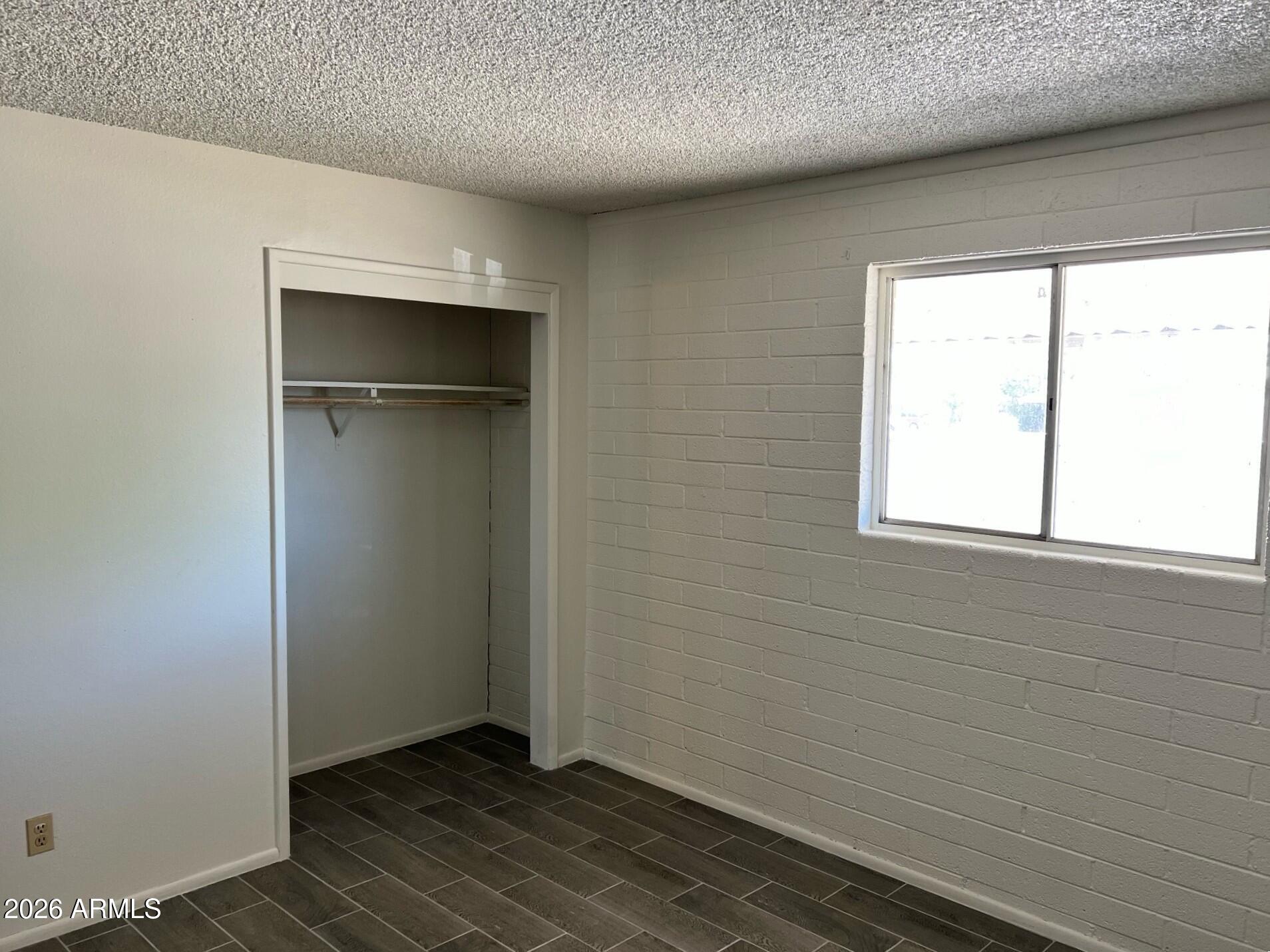 401 Greenwich Road Kearny, AZ 85137 - Photo 19 of 25 a view of an empty room with wooden floor and a window