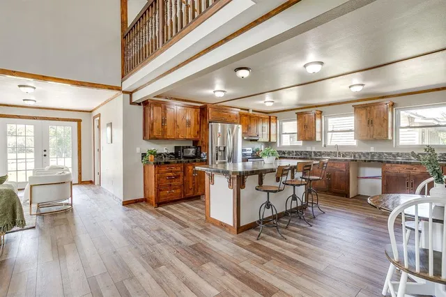 a large white kitchen with lots of counter space a sink and stainless steel appliances