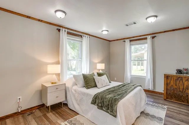 a bedroom with a large bed and wooden floor