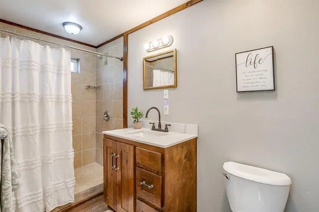 a bathroom with a toilet a sink and a mirror