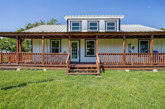 a view of a house with a deck and a yard