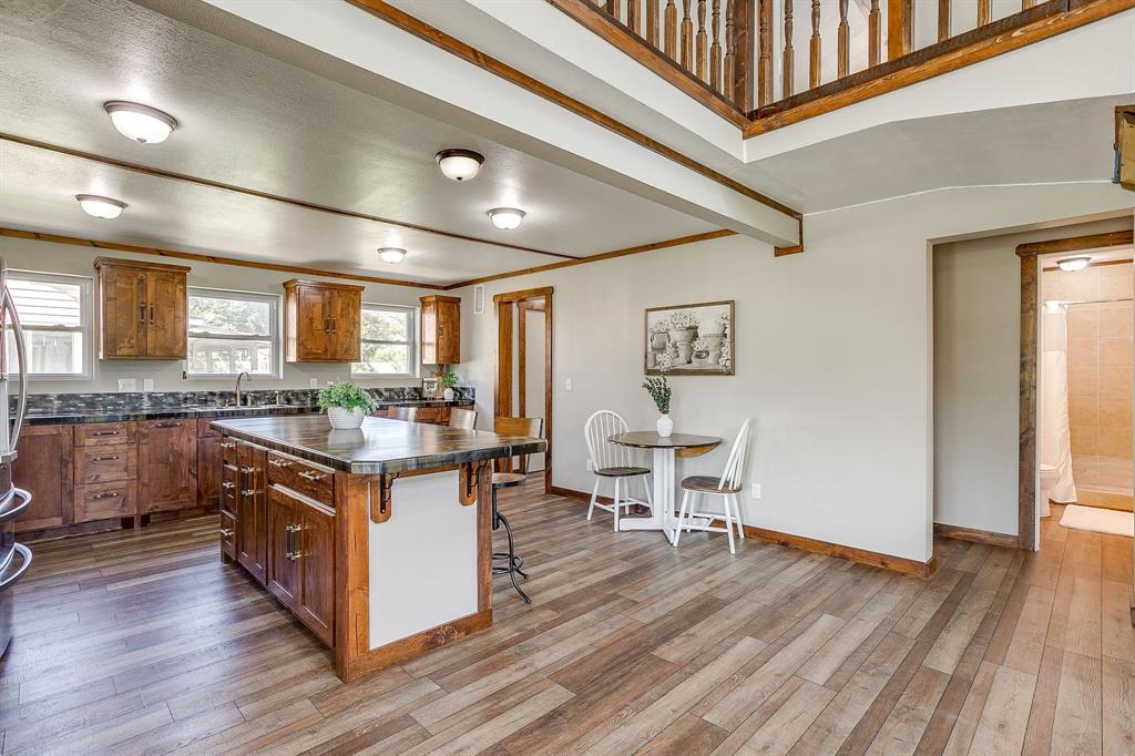 607 East Main Street Itasca, TX 76055 - Photo 9 of 40 a kitchen with stainless steel appliances granite countertop wooden floors and white walls