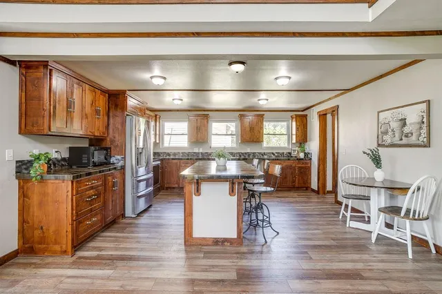 a kitchen with a table chairs microwave and cabinets