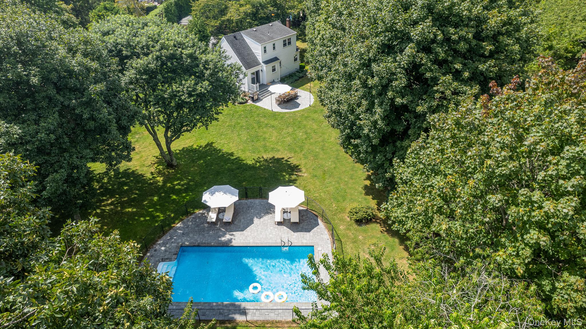 an aerial view of a house with a yard and large trees