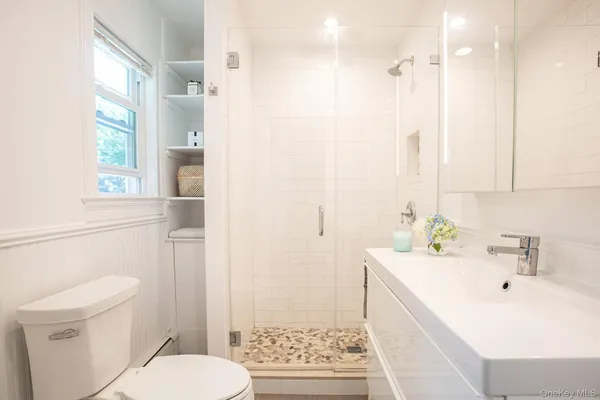 a bathroom with a sink a toilet and shower