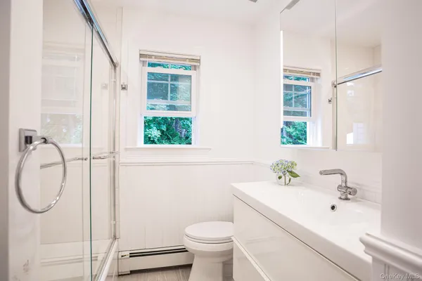 a bathroom with a sink toilet and a mirror