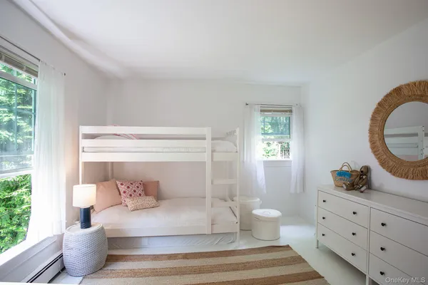 a spacious bedroom with a bed and a dresser