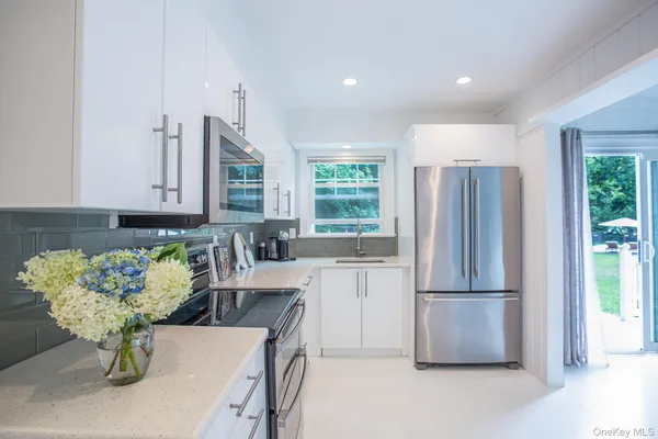 a kitchen with furniture wooden floor and stainless steel appliances
