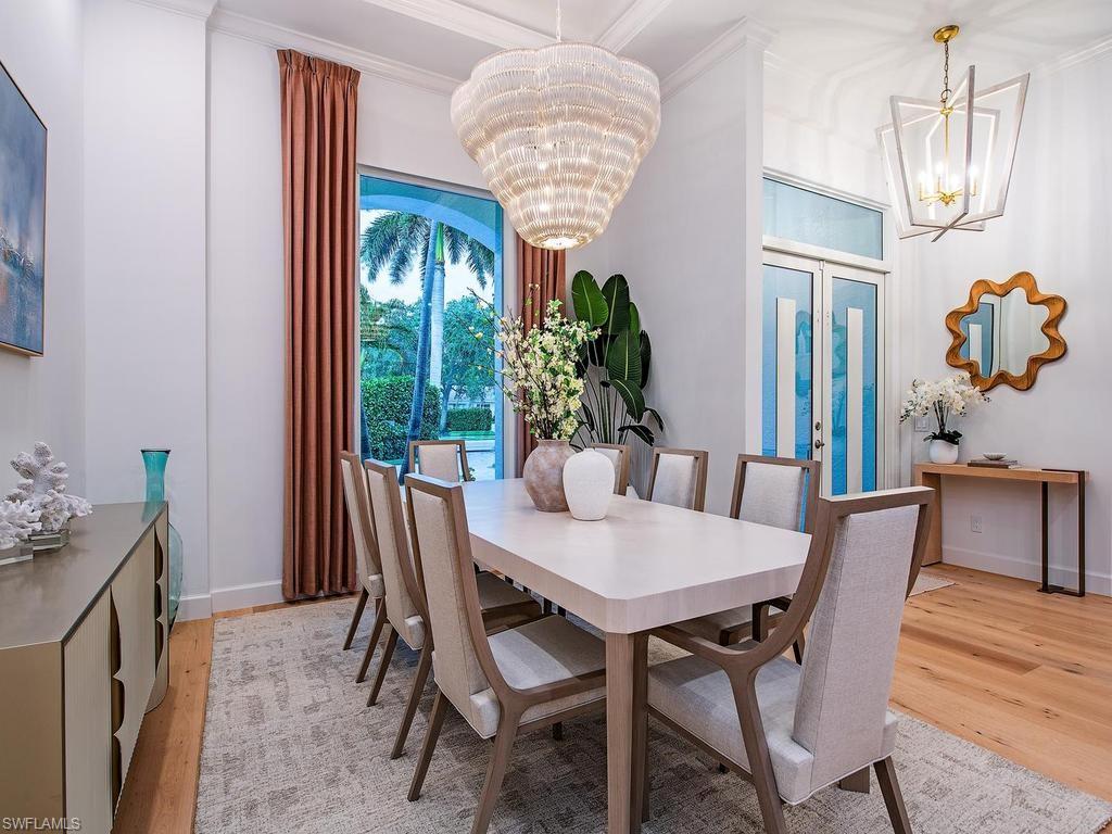 2363 Crayton Road Naples, FL 34103 - Photo 18 of 30 Formal dining space featuring a large sliding glass door, white crown molding, and light wood-finish flooring
