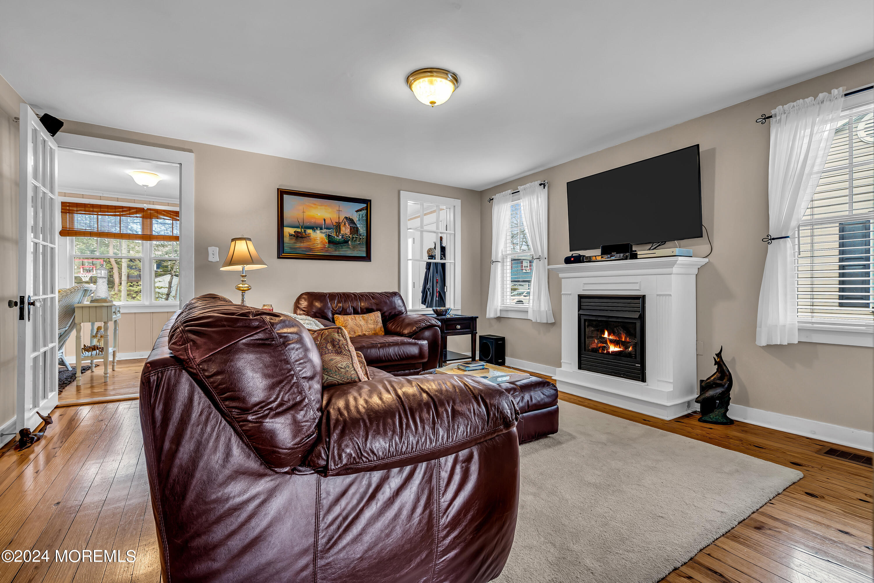 2412 Dunkle Road Point Pleasant, NJ 08742 - Photo 12 of 51 a living room with furniture a flat screen tv and a fireplace