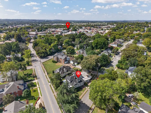 an aerial view of residential houses with outdoor space and trees