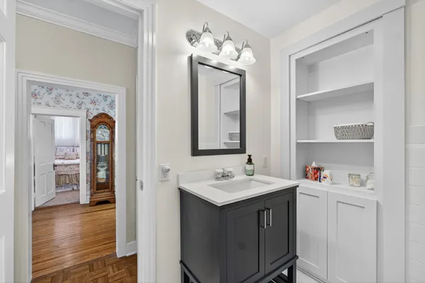 a en suite bathroom with a granite countertop sink a mirror and shower