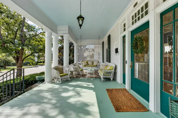 a living room with patio furniture and a rug