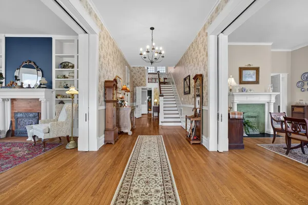 a living room with furniture a fireplace and a chandelier