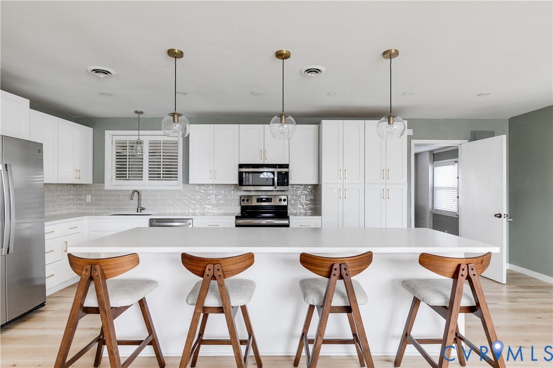 9814 Durango Road Henrico, VA 23228 - Photo 8 of 27 a kitchen with stainless steel appliances kitchen island granite countertop a table and chairs in it