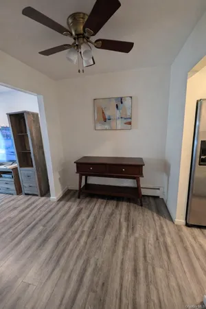 a view of a livingroom with wooden floor and a ceiling fan