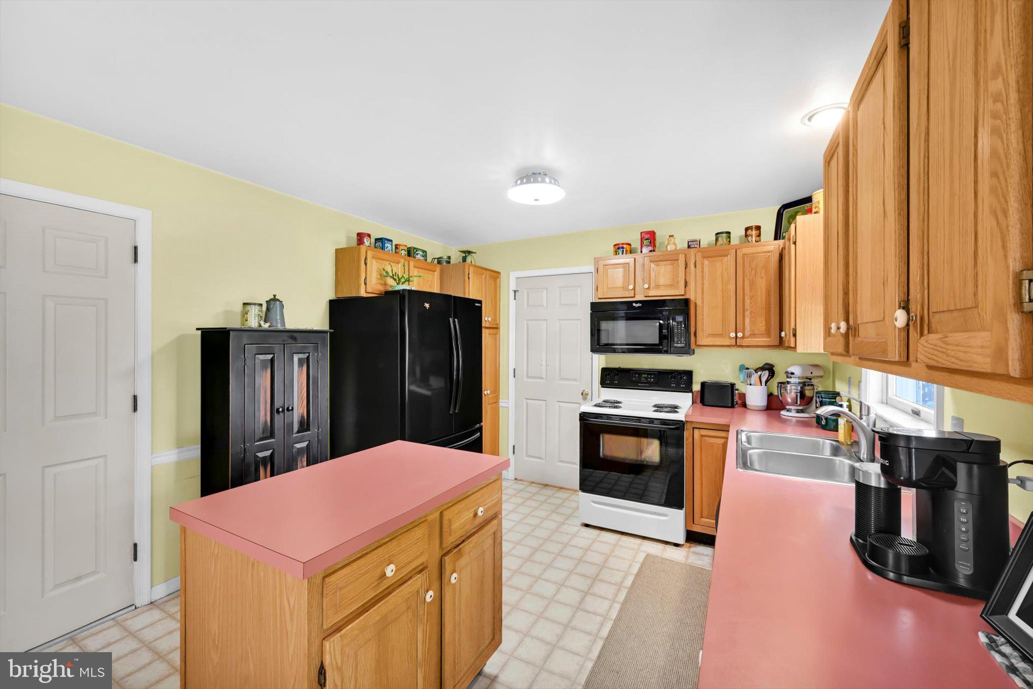 30 Edgewood Drive Lititz, PA 17543 - Photo 12 of 47 a kitchen with stainless steel appliances kitchen island granite countertop a refrigerator a stove top oven and a sink with wooden floor