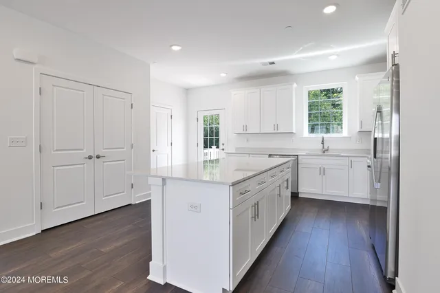 a large kitchen with a lot of counter space and wooden floor