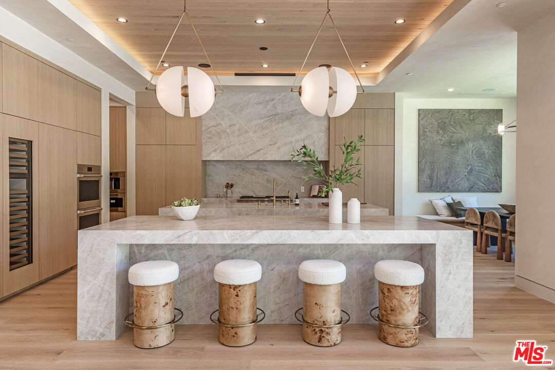 17321 Rancho Street Encino, CA 91316 - Photo 14 of 52 a large kitchen with a table and a chandelier