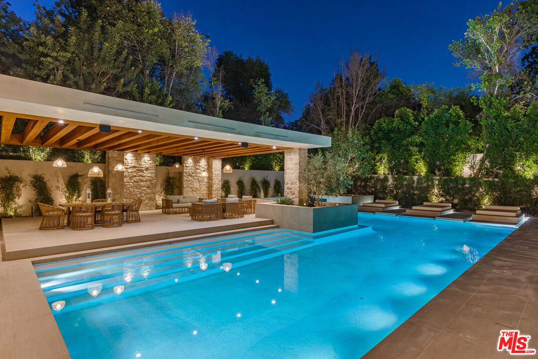 17321 Rancho Street Encino, CA 91316 - Photo 22 of 52 a view of a swimming pool with chairs in patio