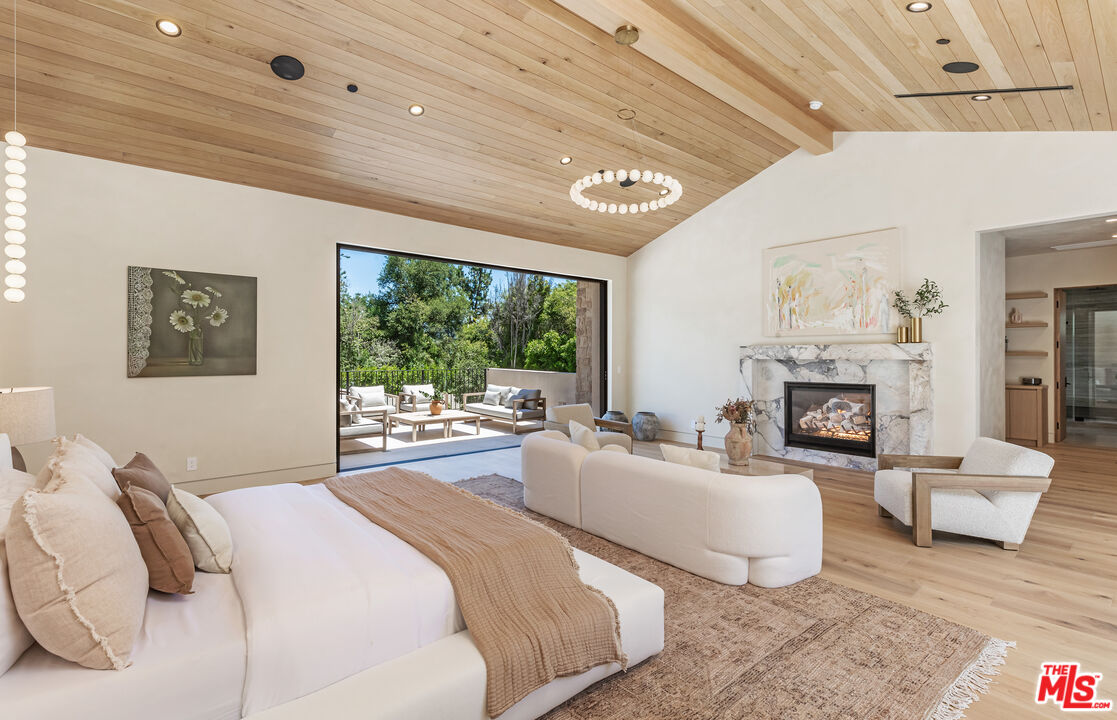 17321 Rancho Street Encino, CA 91316 - Photo 26 of 52 a bedroom with a large bed and a fireplace
