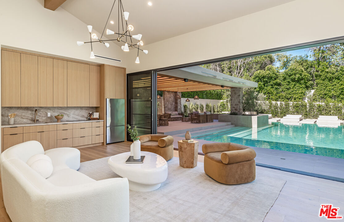 17321 Rancho Street Encino, CA 91316 - Photo 44 of 52 a living room with patio furniture and a swimming pool
