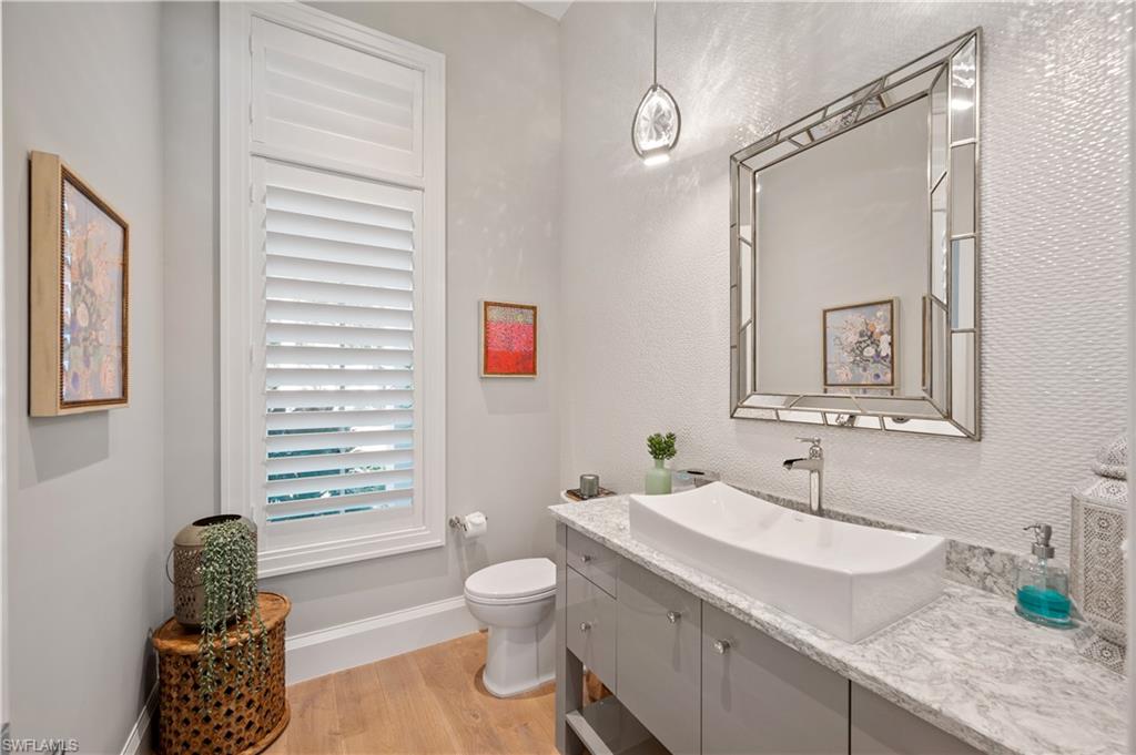 680 Yucca Road Naples, FL 34102 - Photo 18 of 31 a bathroom with a granite countertop sink mirror vanity and toilet