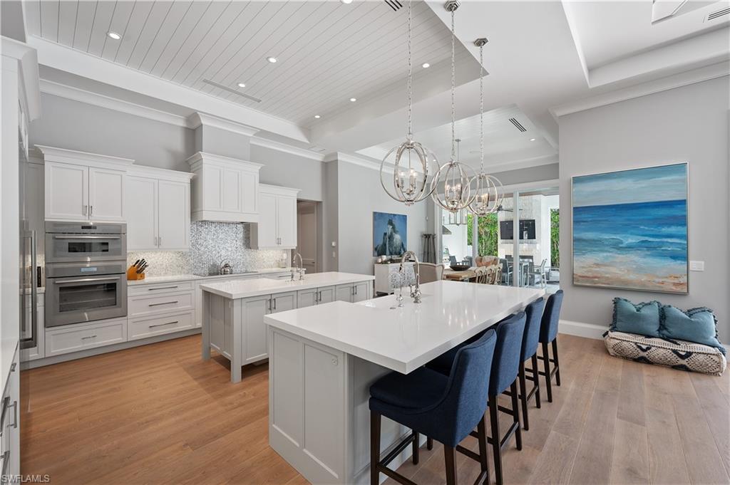 680 Yucca Road Naples, FL 34102 - Photo 8 of 31 a kitchen with counter space dining table and stainless steel appliances